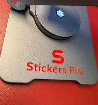 Pegatina de metal color rojo sobre soporte tableta Pegatina de metal color rojo sobre soporte tableta